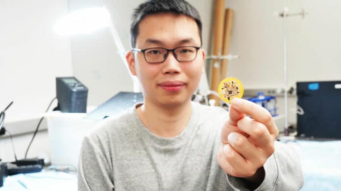 Jiuyun Shi holds a small device he and a team of University of Chicago scientists invented.