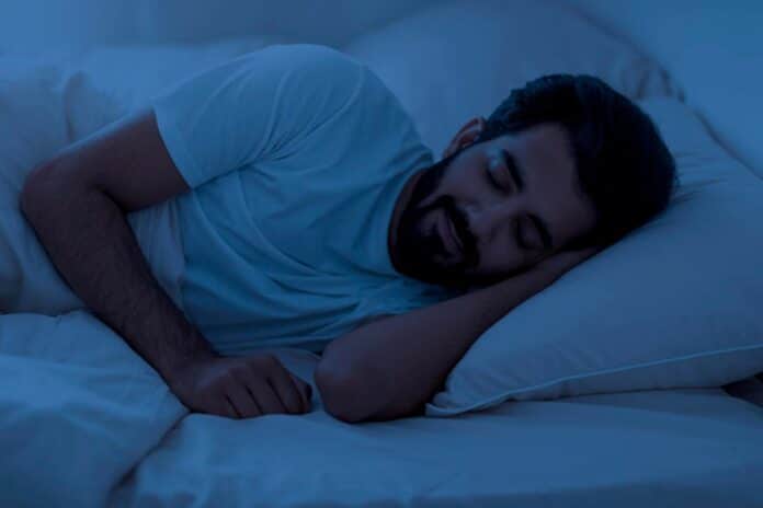 Healthy sleeping portrait of young indian man lying in bed in night