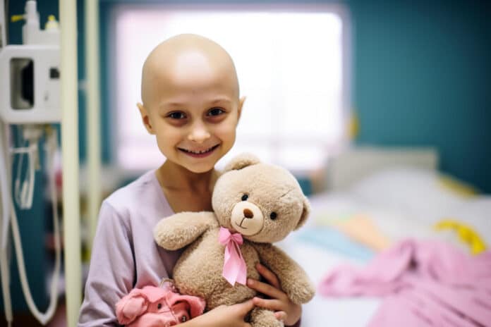 Little girl after chemotherapy with toy bear in clinic