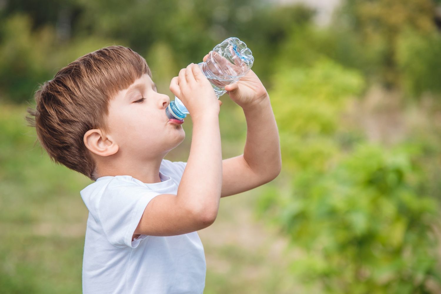 Portrait young boy drinking water